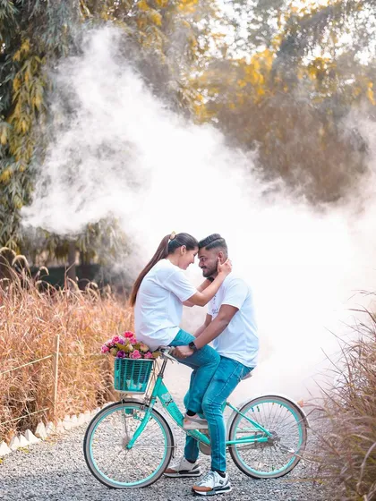 A whimsical and romantic shot featuring our vintage bicycle prop surrounded by colored smoke. This image highlights how I blend playful props with special effects to create unique and dreamy couple portraits.