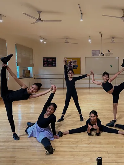A moment of fun and flexibility before the formal exam. Even during a serious assessment, we encourage our students to express their joy for dance. Their passion shines through in poses like these.