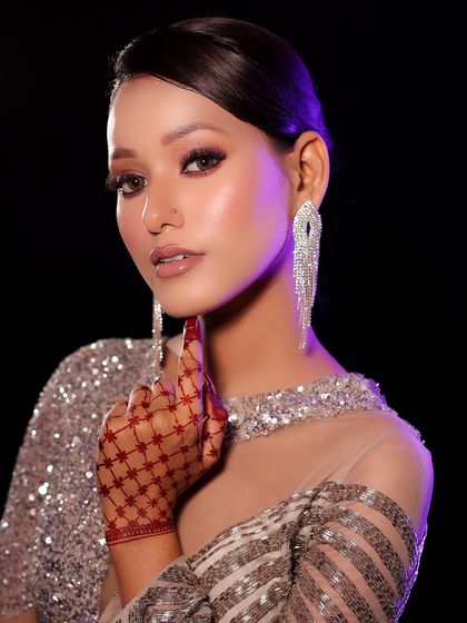 Another angle of the sparkling silver dress look, highlighting the intricate henna design on the hand.