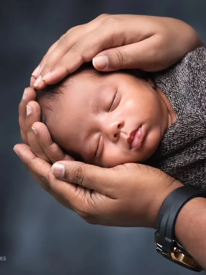 The safety and comfort of your newborn are my top priorities. This classic shot, with a sleeping baby cradled securely in their parent's hands, highlights the delicate, peaceful moments I aim to capture during my newborn photography sessions.