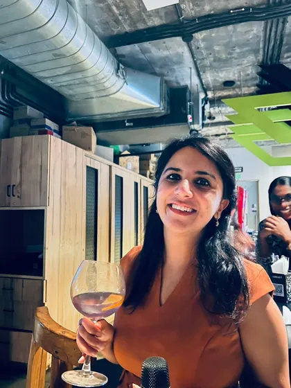 A guest enjoying a glass of wine, ready to take the stage for her karaoke song.