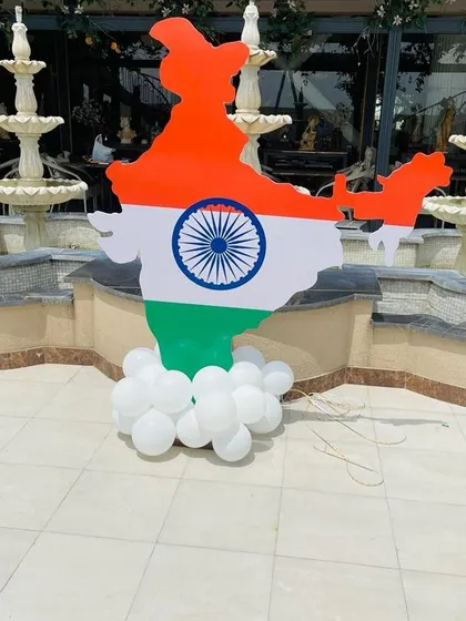 A large cutout of the map of India, colored like the flag, stands on a base of white balloons. This prop is perfect as a standalone decoration or as part of a larger photo booth setup.
