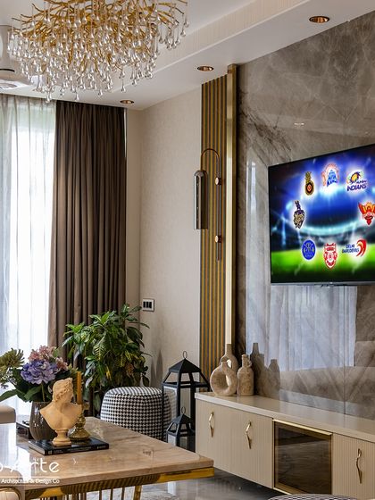 Settle in for the IPL action in ultimate comfort. This living room decor, with its marble feature wall and elegant chandelier, provides a luxurious setting to enjoy the match.