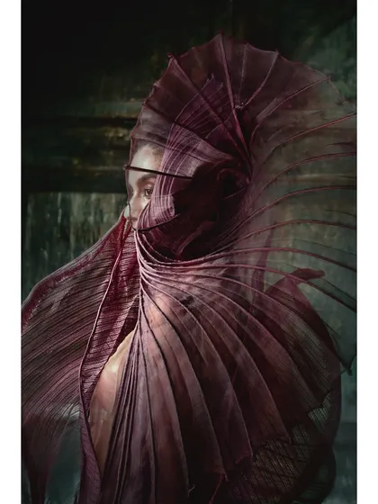 A mysterious and captivating shot from the Vaishali S. campaign. The model's face is partially obscured by the sculptural, deep purple garment, creating intrigue and focusing all attention on the fashion piece.