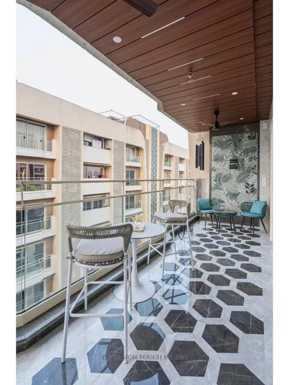A wide view of the balcony, showing the different seating options and the stunning city view. The design proves that even a narrow balcony can be a luxurious and functional space.