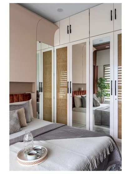 A Scandinavian-inspired wardrobe with cane shutters and integrated mirrors. This piece adds texture and warmth while keeping the bedroom feeling light and airy.
