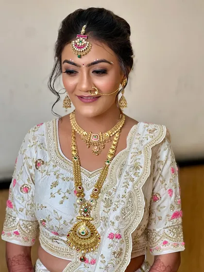 A close-up of the soft, glowy makeup for this bride in white. The subtle shimmer on the eyes and the warm nude lip create a look that is both elegant and modern.