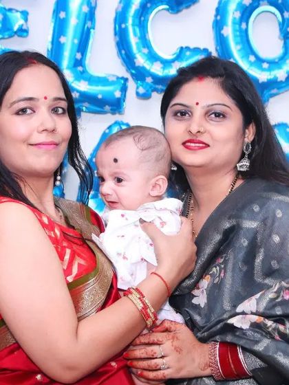 Two women pose with a baby at a 'Welcome, Little Boy' event, celebrating his arrival.