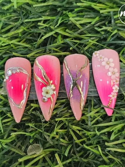 This student work showcases a mastery of color blending and delicate art. The set features a pink ombre base with gold chrome details and tiny, hand-sculpted 3D flowers.