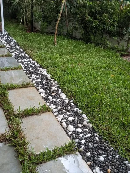 The clean lines of the stone path and pebble border contrast nicely with the organic feel of the lawn.