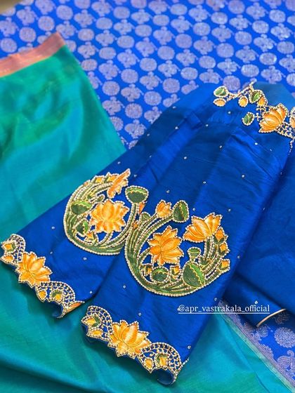 A bright blue blouse with hand-painted yellow lotuses on the sleeves, outlined with beadwork.