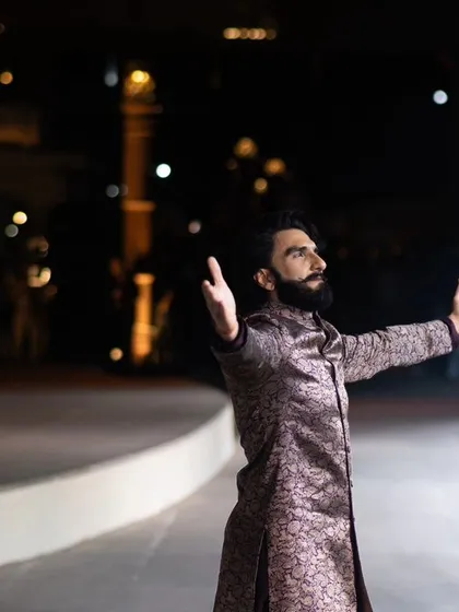 Actor Ranveer Singh commands the stage at Manish Malhotra's 'Dharohar Kashi Ki' show in Varanasi. This image captures his dramatic entrance, blending high fashion with the city's spiritual aura.