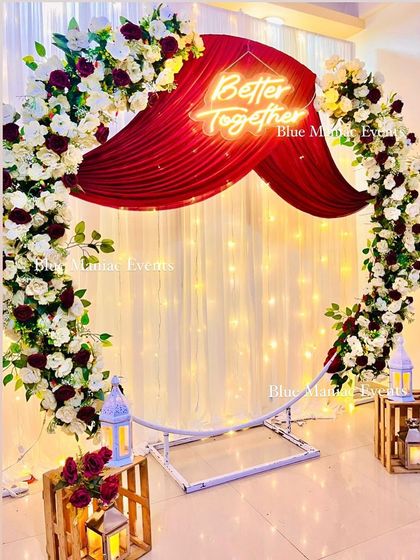 A slightly different angle of the white and maroon setup, showcasing how the lighting and floral arrangements create a captivating focal point in the room.