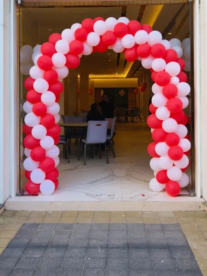 A full view of the simple and elegant red and white balloon arch, proving that even basic decor can be beautiful and impactful when done right.