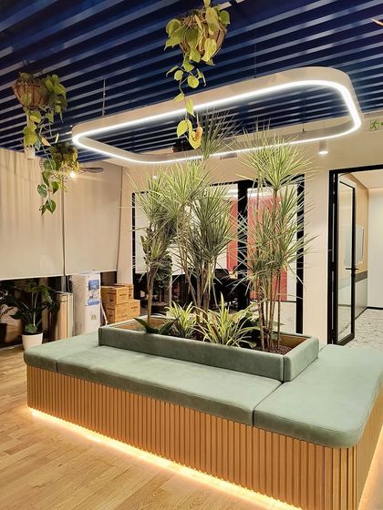 Another view of the central seating planter, this time featuring Dracaena plants. The hanging vines above and the upright plants in the center create layers of green that make the space feel vibrant and full of life.