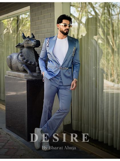Leaning back with effortless style. This image showcases the clean lines and modern fit of the light blue suit, a perfect blend of classic tailoring and contemporary design.