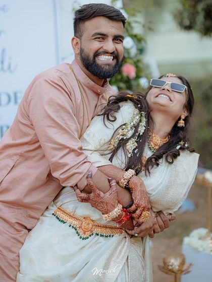 A fun, candid moment from Anudeep and Sharda's Haldi, where the groom playfully lifts the bride in a joyful hug.