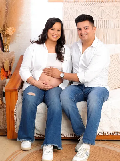 A beautiful, happy portrait of the couple looking directly at the camera, showcasing their shared joy in a comfortable and natural setting.