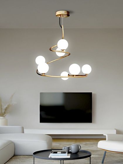 Here, the spiral globe chandelier is shown in a minimalist white living room. Its gold finish provides a beautiful contrast and a focal point in the space.
