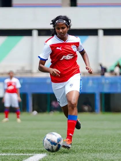We are committed to developing talent in both boys and girls. Here, one of our promising players showcases her skill and determination during a competitive match in the Karnataka Women's League.