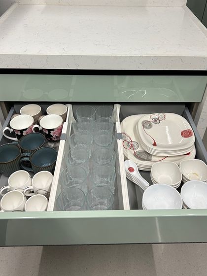 This drawer is set up for daily use with mugs, glasses, and a dinner set. Using dividers keeps everything neat and prevents chipping.
