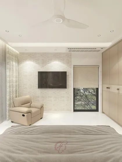A view from the bed towards the TV wall, showing a comfortable recliner and large windows that fill the room with light.