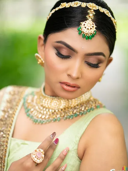 A beauty shot focusing on the model's makeup and jewelry, with her eyes closed to highlight the eyeshadow.
