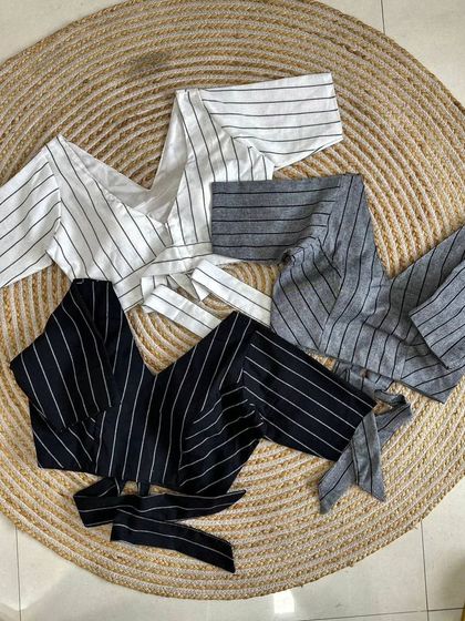 A flat-lay of the striped cotton blouses, showing the V-neck and tie detail.