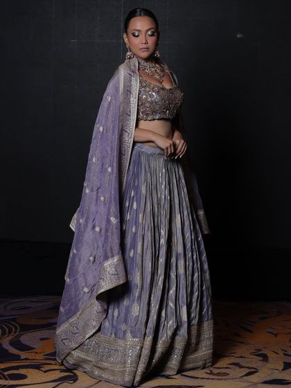 A full-length shot showing how a statement choker can elevate even a simple, elegant lehenga.