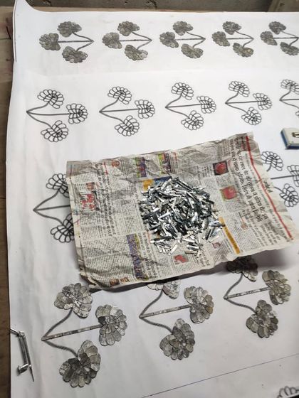 The process of creating Thikri involves sketching the design and then carefully arranging tiny, hand-cut pieces of mirrored glass. Here, the glass pieces are ready to be set.