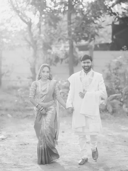 A timeless black and white photo of the couple walking hand-in-hand. This artistic shot adds a classic, dreamy feel to their engagement story.