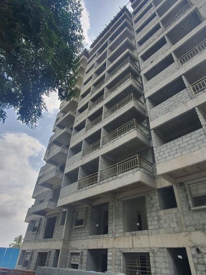 A duplicate image of the apartment building during its construction phase, showing the ongoing blockwork and structural work.