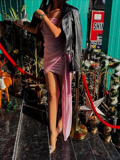 A stylish way to wear a party dress in the cold, with a leather jacket thrown over the shoulders.