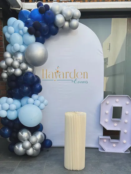 A simple and stylish setup for a 9th birthday. The blue, silver, and navy balloon garland is paired with a large marquee number '9'.