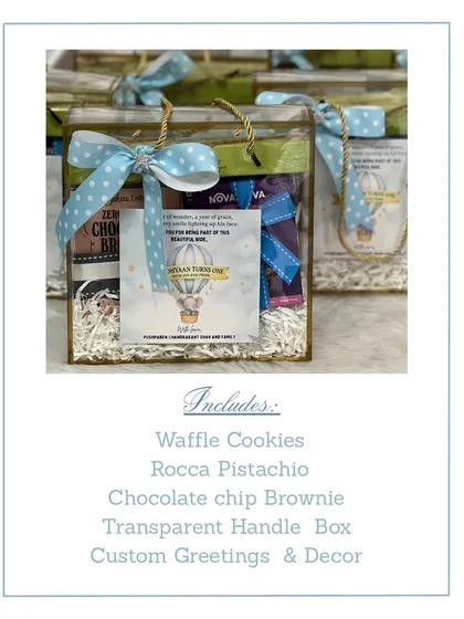 This image shows the contents of our transparent handle box return favor. It includes waffle cookies, pistachio roca, and a chocolate chip brownie, with custom decor to match the birthday theme.