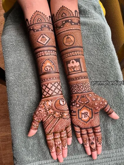 A subtle yet meaningful way to include your partner. This design features the initials "MR" elegantly placed on the palm, surrounded by traditional motifs like elephants and temple bells.