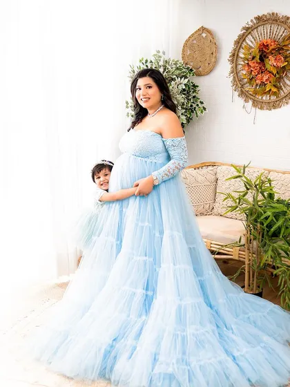 A peek-a-boo moment with the older sister hiding behind mom's beautiful blue gown. It’s these playful, candid shots that show a family's true personality.