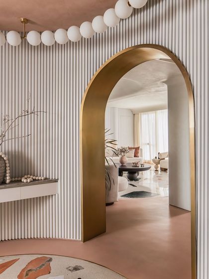 The entrance lobby welcomes you with a custom terrazzo inlay, fluted walls, and a stunning brass-lined archway.