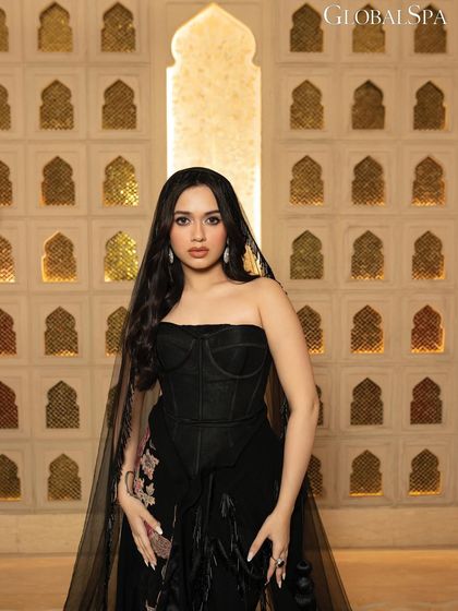 A medium close-up from the GlobalSpa shoot, focusing on Jannat's expression and the intricate details of her outfit's bodice and veil.