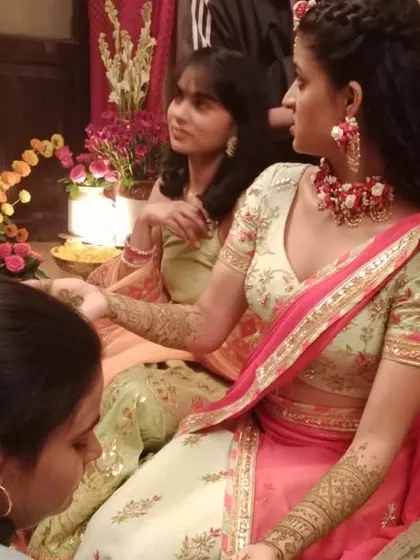 Another shot from the film set, showing the mehendi application in progress.