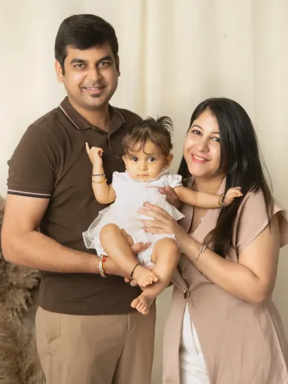 A classic family-of-three portrait in our boho studio setup, with everyone looking happily towards the camera.