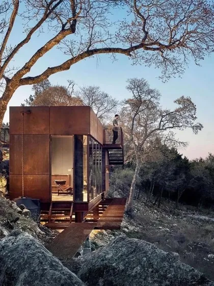 Our designs often incorporate sustainable features, like the rainwater harvesting system seen here on this rustic modular home. We believe in building homes that are not only beautiful but also environmentally responsible.