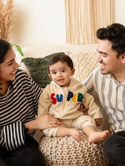 A candid family photo of parents interacting with their one-year-old son on his birthday.