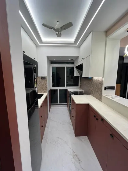 This shot highlights the layered lighting design in the kitchen, with ceiling lights for overall illumination and under-cabinet lights for task areas. Good lighting is essential for both function and ambiance.