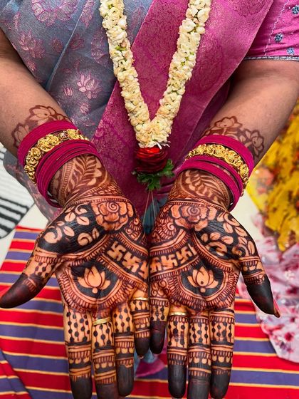 Another view of the hands with bangles, showing the rich color of the henna stain.