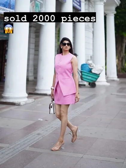 This is my best-selling two-piece set, featuring a sleeveless waistcoat-style top and a matching mini skirt. It's a modern, sharp look for any semi-formal occasion, shown here in a vibrant pink.