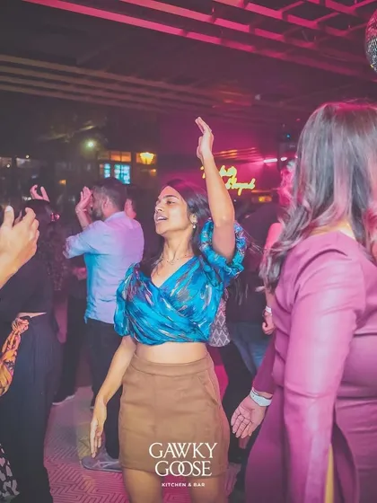 A guest dancing freely under the pink lights of the club.