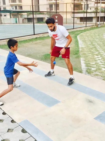 Personal attention makes all the difference. I am working one-on-one with a young athlete on a reaction ball drill, a fun and effective way to sharpen hand-eye coordination and reflexes for faster volleys and returns.