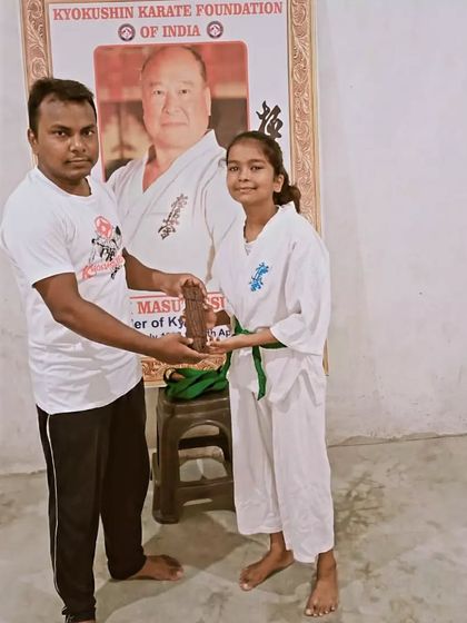 Another student receives her upgraded belt. Her happy face shows how much this means.