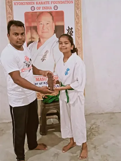 Another student receives her upgraded belt. Her happy face shows how much this means.